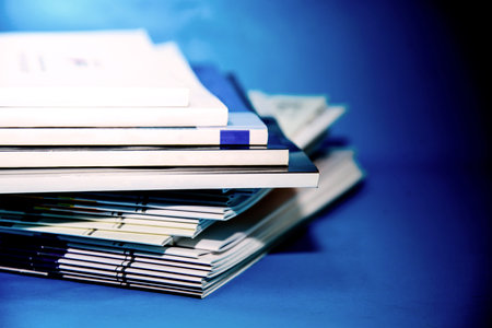 Stack of documents on blue background. Shallow depth of field.