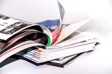Stack of magazines on a white background, close-up, selective focusの写真素材