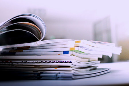 Close up of stack of magazines on the desk. Shallow depth of field