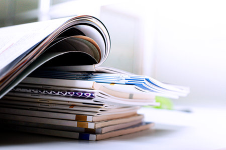 Close up of a stack of magazines on a desk. Shallow depth of fieldの写真素材