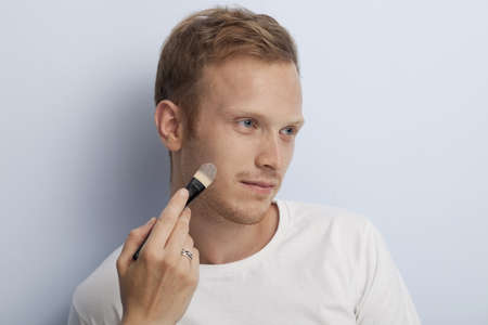 Portrait of young man being served with facial cosmetic treatment の写真素材
