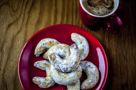 Croissant in the plate with red cup of coffeeの写真素材