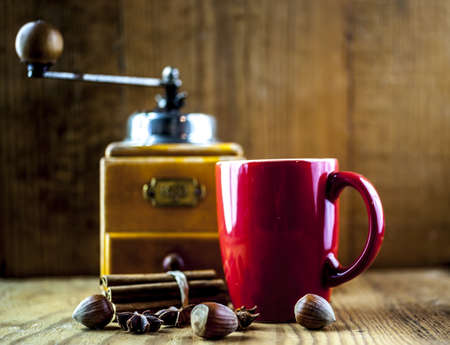 Coffee grinder with cup of coffee and hazelnutsの写真素材