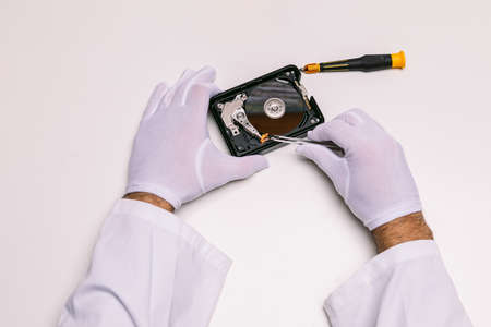 Hands of a technician with gloves repairing a hard drive. Technology maintenance conceptの写真素材