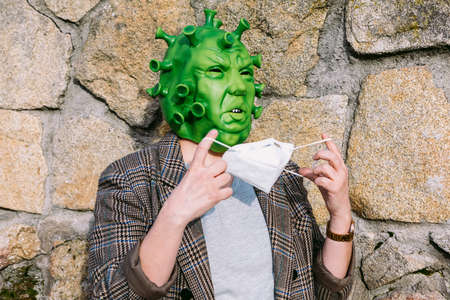 Woman wearing costume -  mask, looking at mobile phoneの写真素材