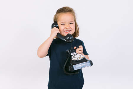 Little blonde girl talking on her retro phoneの写真素材