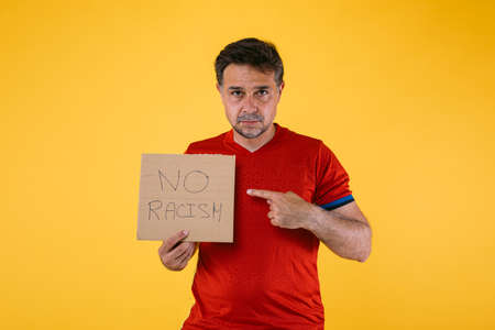 Soccer fan with red jersey and a sign that says 'No racism'の写真素材
