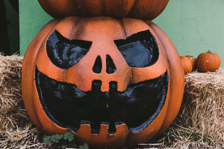 A Halloween decorative dark colored Jack-o-Lantern pumpkin on the street. Halloween and carnival...