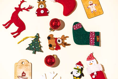 Christmas still life with reindeer, gingerbread man, socks, santa claus and christmas ball, snowflake and penguin decorations on pastel background. Christmas concept, decorations and celebration.の写真素材