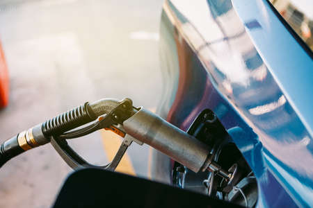 Hose plugged into a car made of LPG (liquefied petroleum gas) fuel at a gas station in a metallic blue car. Refueling, gas station, ecology, transportation and eco concept.の写真素材