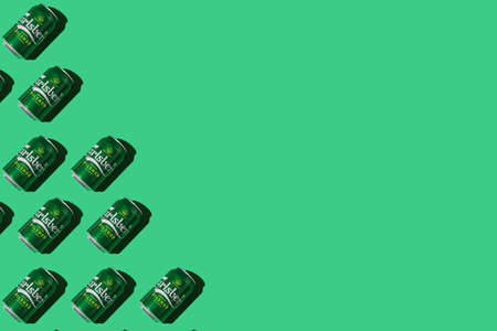 Pattern of green Heineken Dutch beer cans with hard shadow, on the left side, on white background. Alcohol, brewery, industry, factory and bar concept.のeditorial素材