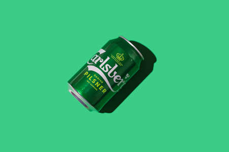 Green can of Dutch Heineken beer with hard shadow on white background. Alcohol, brewery, industry, factory and bar concept.のeditorial素材