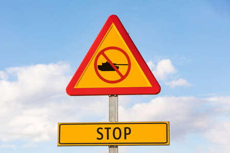 Danger traffic signal with a tank with a prohibited signal and a sign that says: 'STOP', with the sky in the background. Concept of War, Ukraine, Russia and war conflict.の写真素材