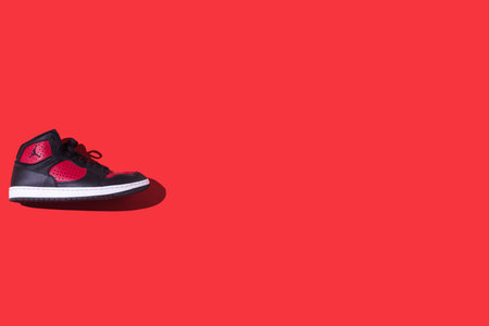 Black and red NIKE Jordan Access shoes, on the left side, on a red background. Concept of sneaker, basketball, retro, michael jordan, fashion, collection and casualのeditorial素材