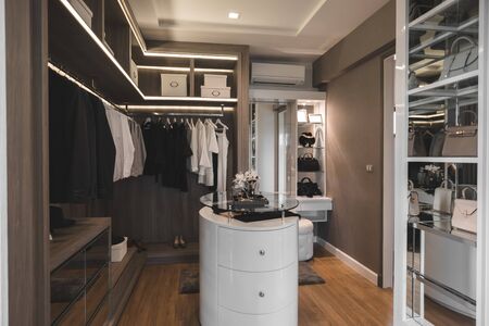 Modern walk in closet room with cloths and bags in the shelf furniture and wooden floorのeditorial素材
