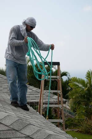 Man lowering the safety rope used for working on the roof.の写真素材