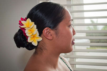 A young bride in Hawaii stares out the window in antisapation of her wedding.の写真素材
