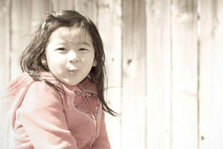 Young Girl Blowing Kisses-Faded Photo Treatmentの写真素材