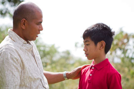 Ethnic father talking to his son outside.の写真素材