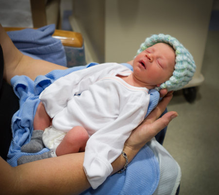 Grandmother holds her newborn grandson while he sleeps in a state of complete relaxation.