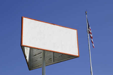Blank white wooden sign next to a flagの写真素材