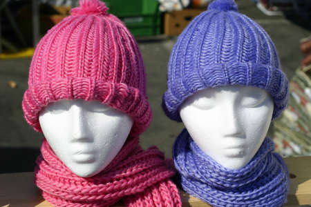 Two mannequins with pink and purple hats and scarvesの写真素材