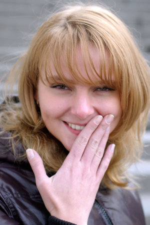 Smiling pretty lady with light-brown hair in black jacket