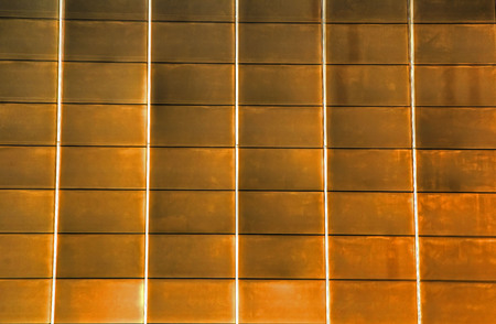 Glass panes reflecting yellow sunlight with linesの写真素材