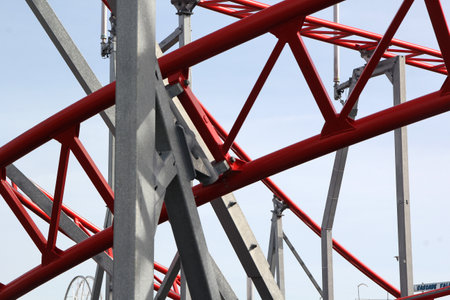 Metal roller coaster close up with red rails in an amusement parkの写真素材