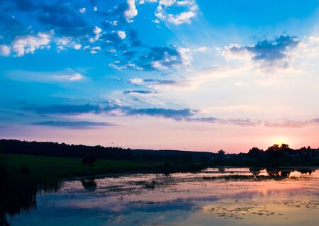Decline in clouds of the sun with beams backgroundの写真素材