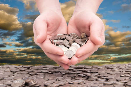 woman's hands holding a handful of coinsの写真素材