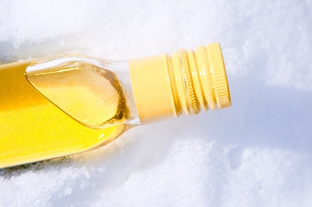 bottle with yellow liquid in the snowの写真素材