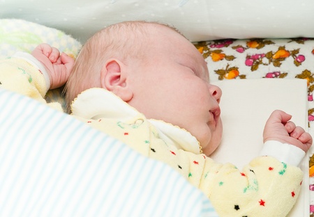 little newborn baby sleeps with his mouth openの写真素材
