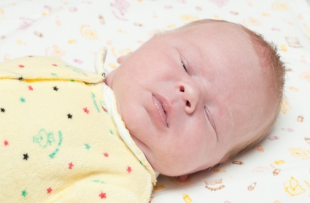 little newborn baby sleeps with his mouth openの写真素材