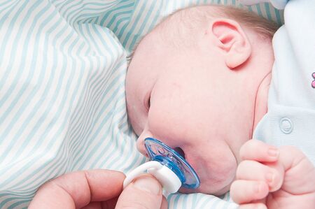 little newborn baby sleeps with his mouth openの写真素材