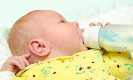 newborn baby is eating from a bottleの写真素材