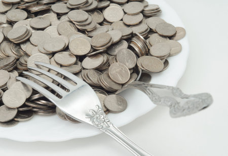 small coins on a plate with cutlery