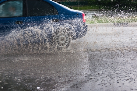 Car rides on big water in the rainの写真素材