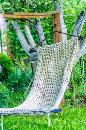 old hammock hanging in the gardenの写真素材