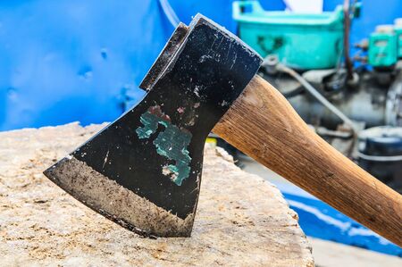 an old ax stuck in a wooden deckの写真素材