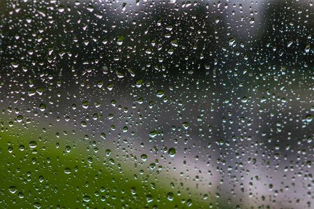 rain drops on glass with a backgroundの写真素材