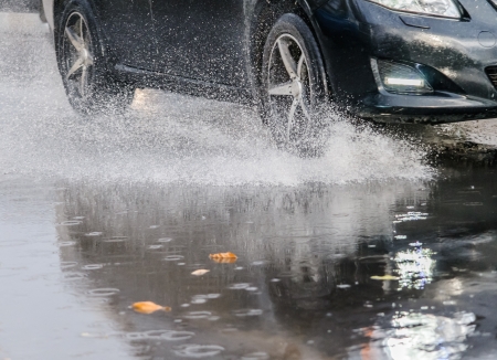 Car rides on big water in the rainの写真素材