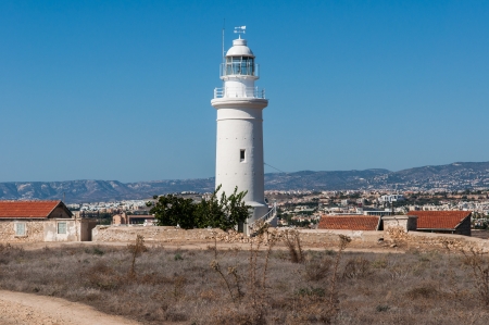 Coast white lighthouse against a blue sky on the island of Cyprusの写真素材