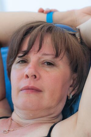 The woman lies sunbathes on sea beachの写真素材