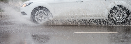 Car rides on big water in the rainの写真素材