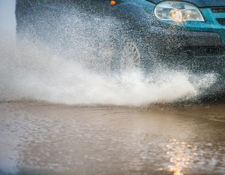 Car rides on big water in the rainの写真素材