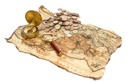 compass and magnifying glass gold color on the old map with coinsの写真素材