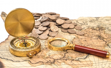 compass and magnifying glass gold color on the old map with coinsの写真素材