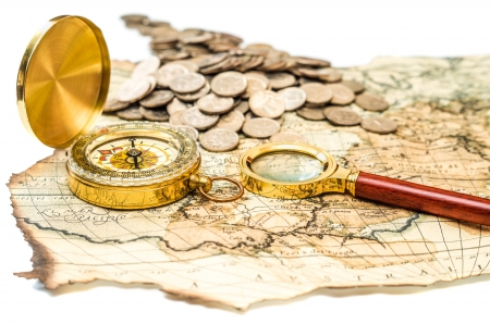 compass and magnifying glass gold color on the old map with coinsの写真素材
