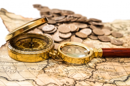 compass and magnifying glass gold color on the old map with coinsの写真素材